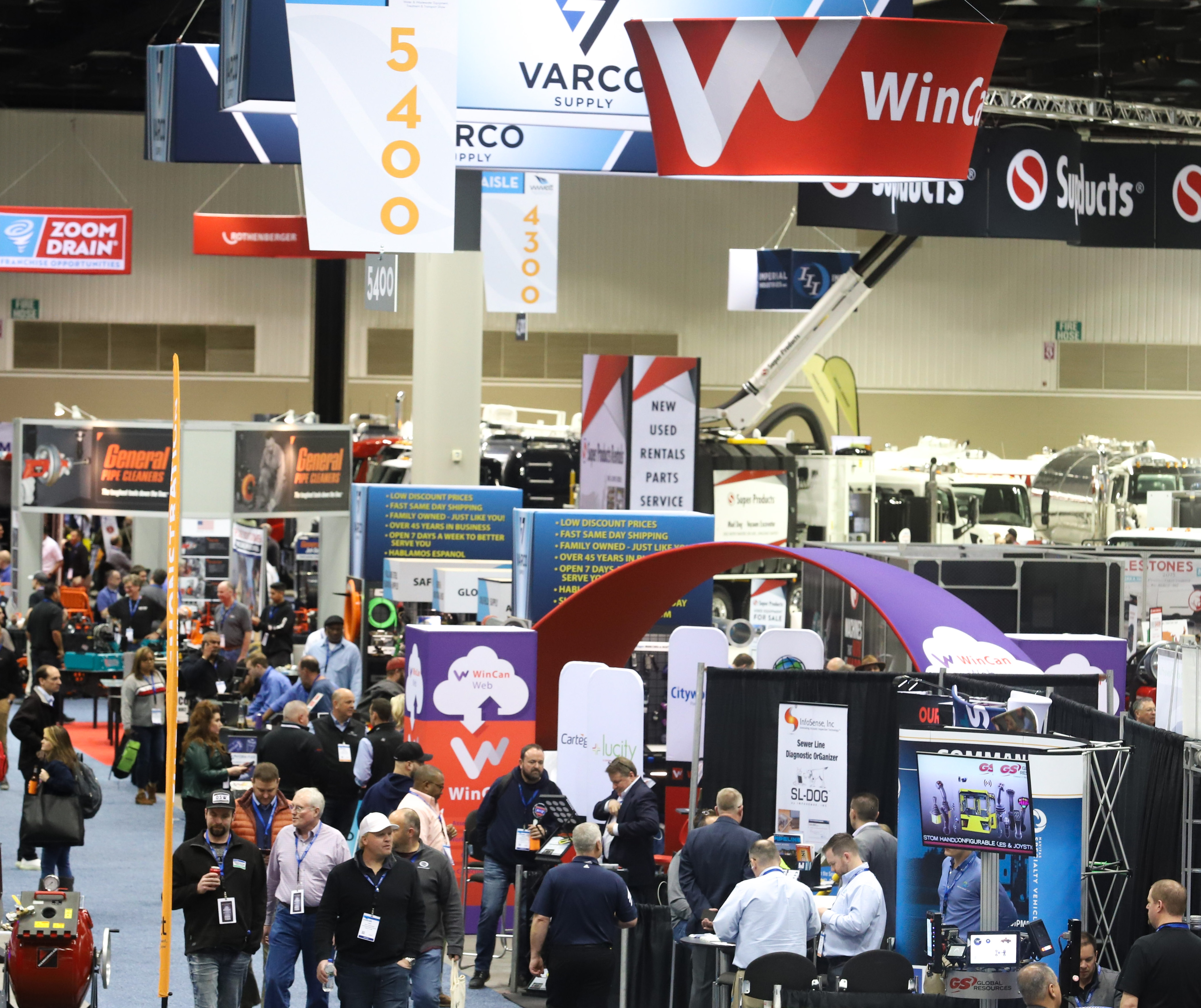various exhibit booths many people walking exploring the expo hall