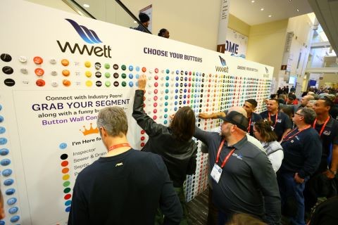 wwett button wall with attendees taking buttons