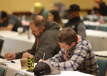 2 attendees taking notes at a table in an education session