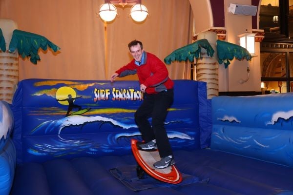 Man on surfboard at WWETT welcome party