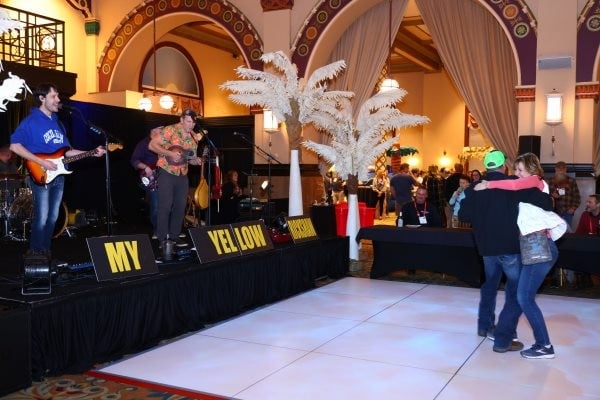 2 people dancing on the dance floor in front of the stage at the WWETT welcome party